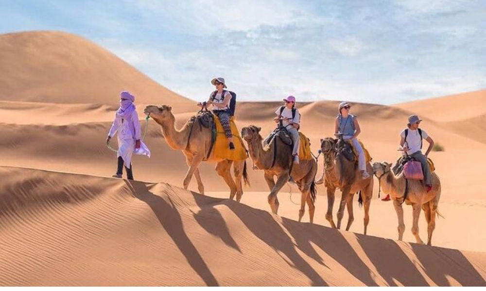 Camel Trek in Merzouga – 5-Day Desert Tour from Marrakech Camel trek in the golden dunes of Merzouga during a 5-Day Desert Tour from Marrakech.