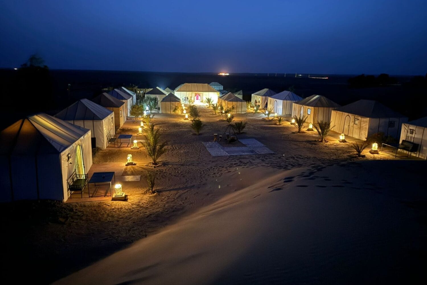 Dune Merzouga Camp glowing at dusk in the Erg Chebbi desert